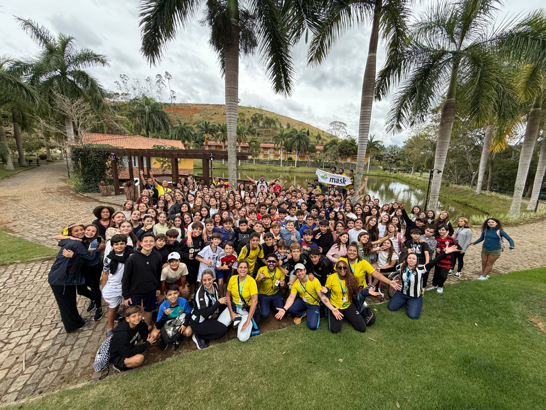 Grande grupo de estudantes com a bandeira da MASK em viagem de campo