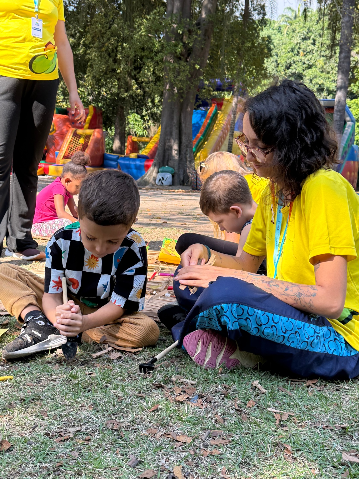 Educadora MASK com crianças em oficina ao ar livre