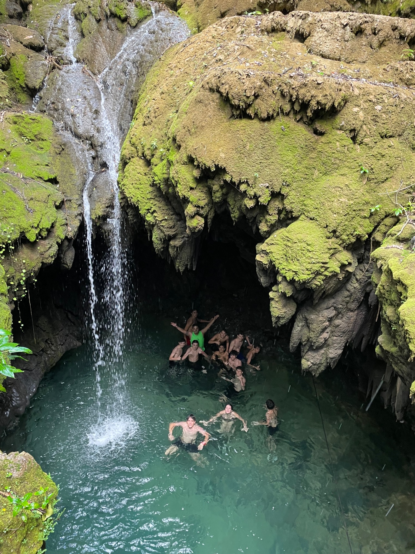 Estudantes se banhando em poço com cachoeira durante viagem pedagógica