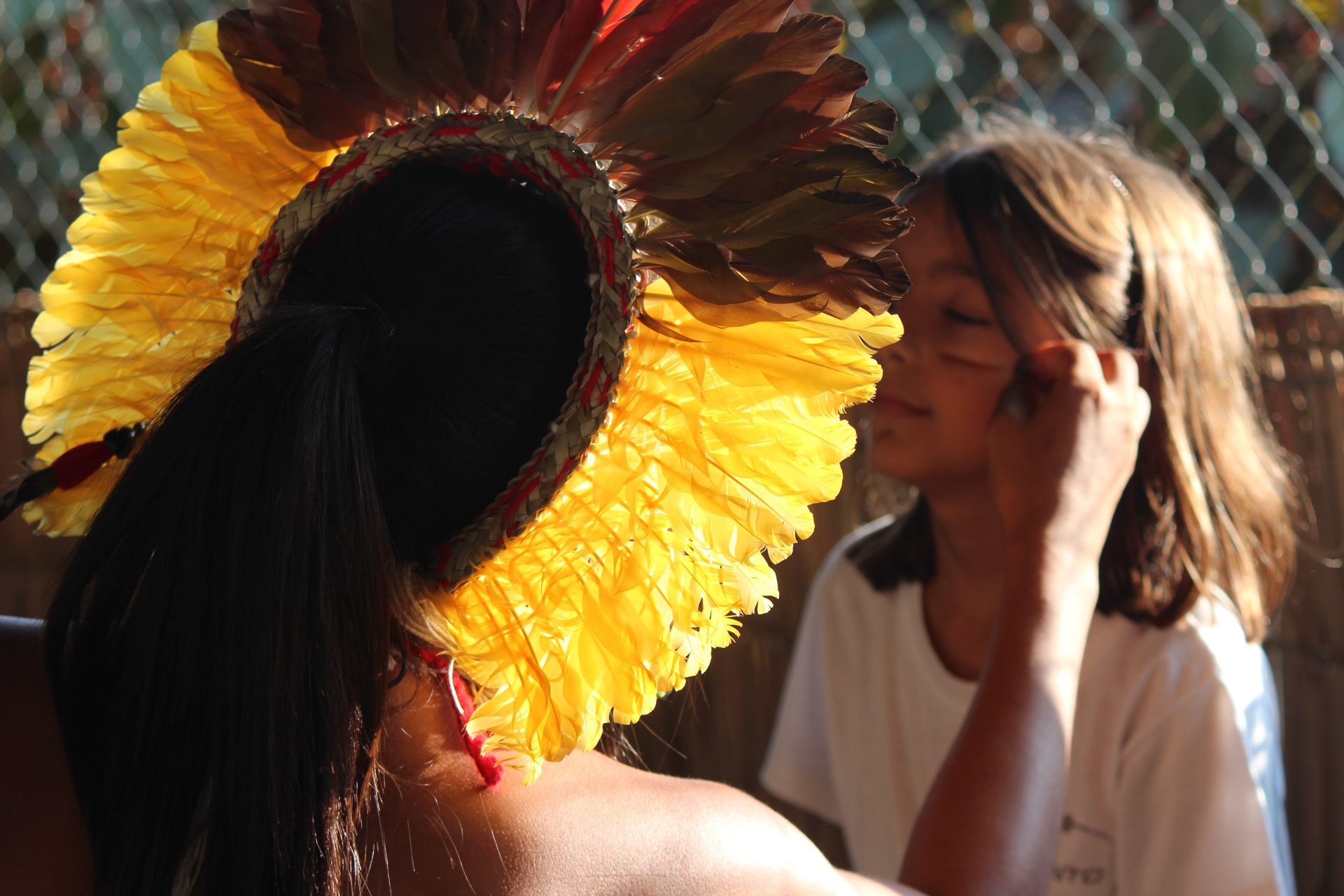 Estudante com cocar de penas em atividade cultural