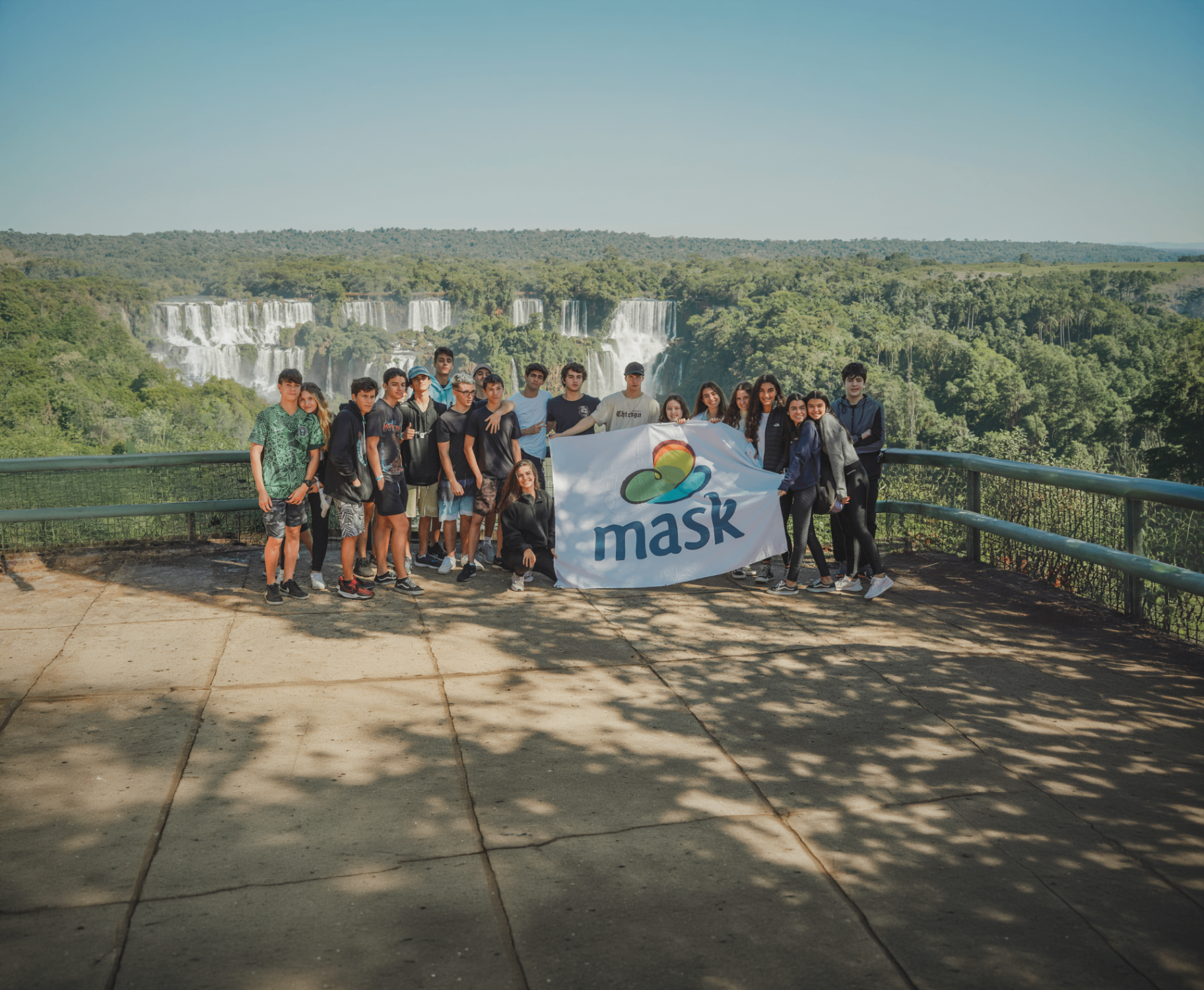 Grupo de estudantes com a bandeira da MASK nas Cataratas do Iguaçu
