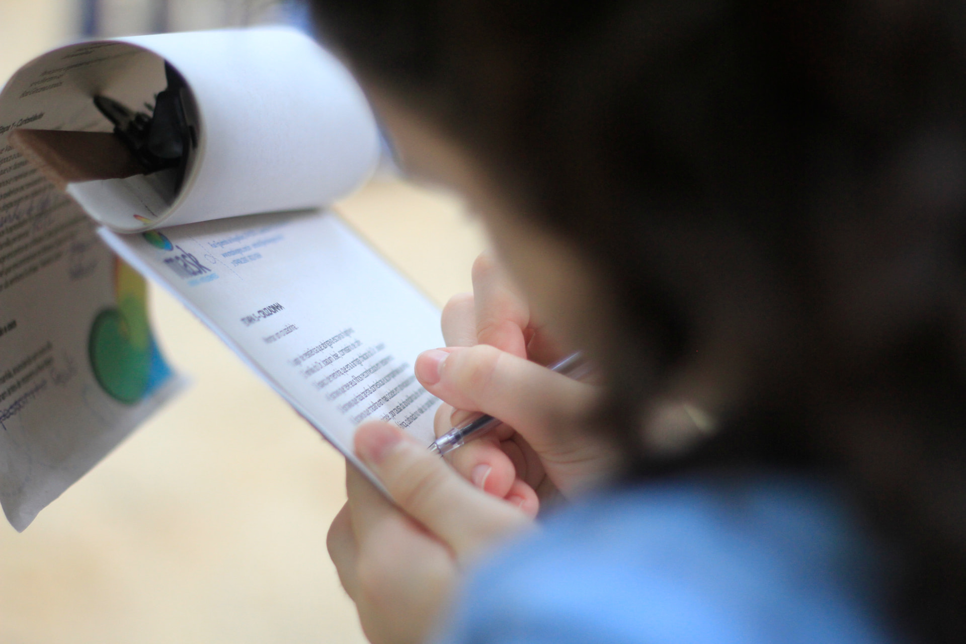 Estudante escrevendo em caderno durante atividade